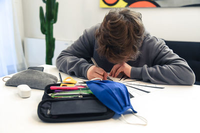 Close-up of boy studying at home