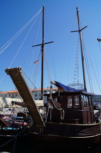 Sailboats moored at harbor against sky