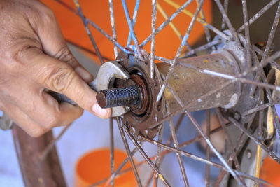 Close-up of man working on bicycle