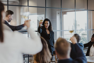 Cheerful business people toasting wineglasses during company party