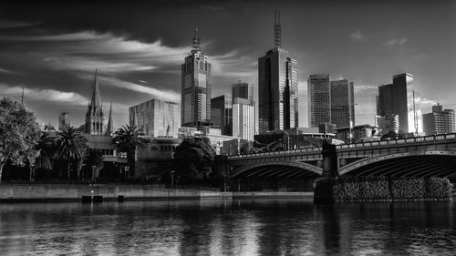 View of skyscrapers in city against cloudy sky