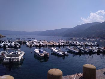 Sailboats moored in sea against sky