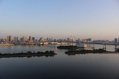 City by river against clear sky