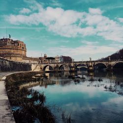 Hadrian tomb by tiber river against sky