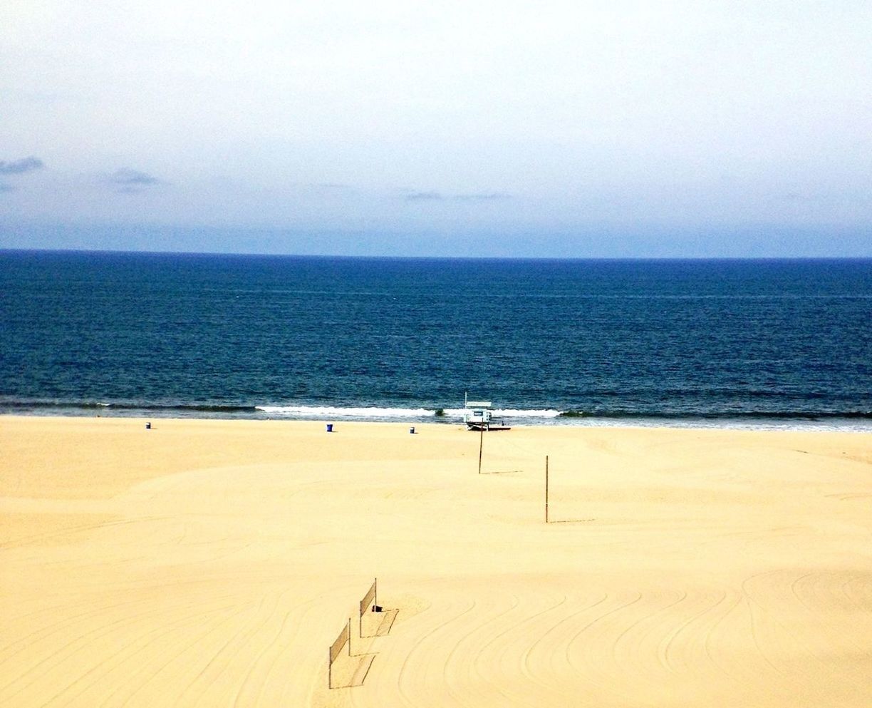 sea, horizon over water, beach, sand, water, tranquil scene, shore, scenics, tranquility, beauty in nature, clear sky, copy space, nature, sky, incidental people, vacations, idyllic, day, outdoors, remote