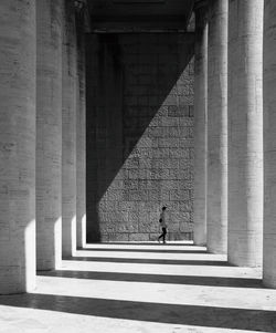 Shadow of woman walking on colonnade