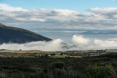 Scenic view of mountains against cloudy sky