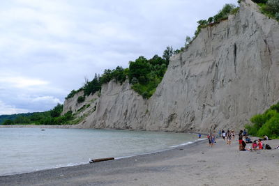 People at beach against sky