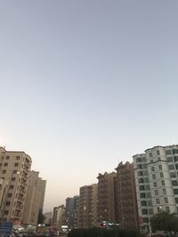 Buildings in city against clear sky