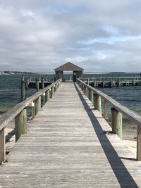 Wooden pier over sea against sky