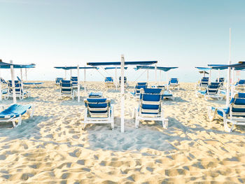 Chairs on beach against clear sky