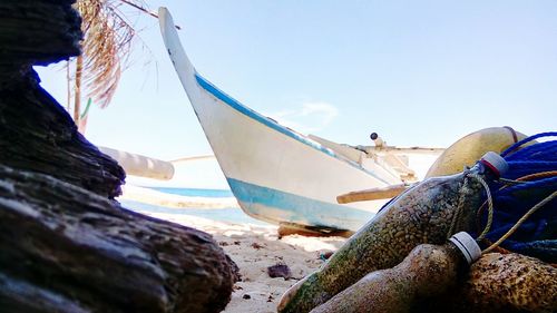 Close-up of ship moored on beach against clear sky