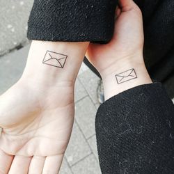 Cropped hands of women with tattoo on wrist