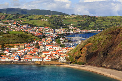 Aerial view of town by river and buildings in city