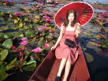 Woman standing by pink flowering plants