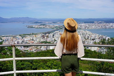 Back view of traveler girl on morro da cruz in florianopolis city, santa catarina, brazil.