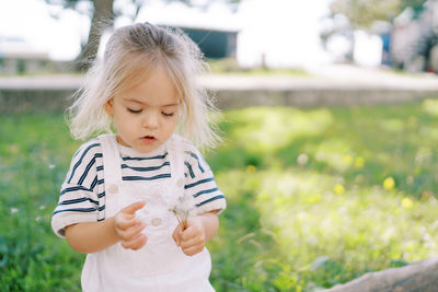 Portrait of cute girl looking away while sitting on field