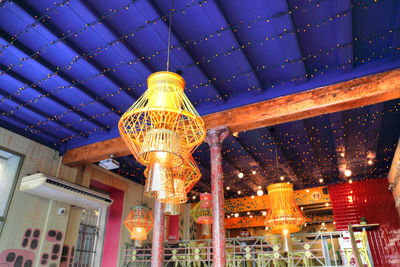 Low angle view of illuminated lanterns hanging in building at night