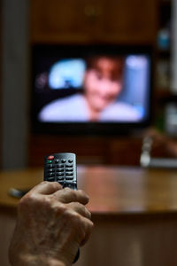 Close-up of an old man changing channels