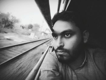 Man looking through window in train