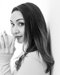 Close-up of young woman against white background