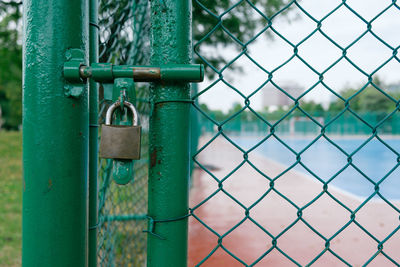 Close-up of padlock on chainlink fence