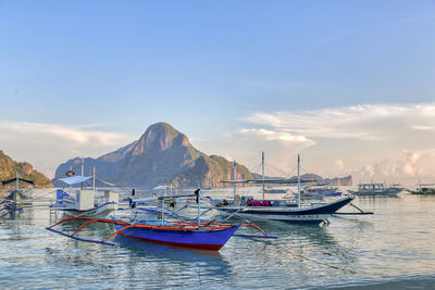 Boats moored in sea against sky