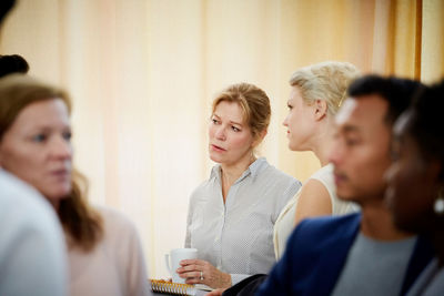 Female entrepreneurs discussing while looking away in business meeting