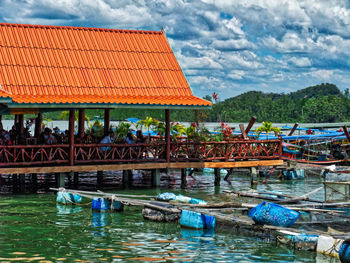 View of boats moored in water against cloudy sky