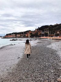 Rear view of woman walking on beach