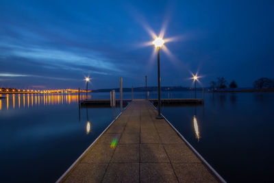 Pier in sea at sunset