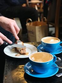 Close-up of hand holding coffee served on table