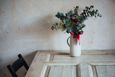 Close-up of vase with bunch of flowers on table