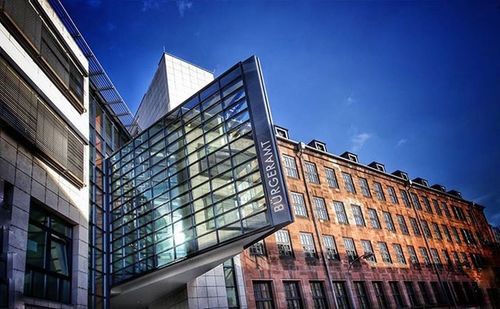 Low angle view of modern building against blue sky