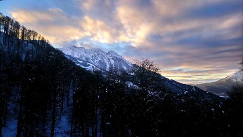 Scenic view of snowcapped mountains against sky during sunset