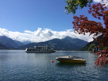 Boats on river by mountains against sky