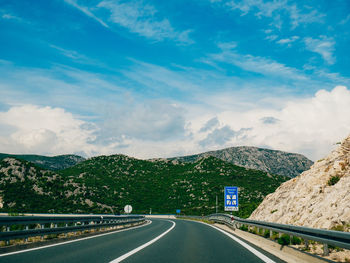 Empty road along landscape against sky