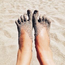 Low section of person legs on sand at beach