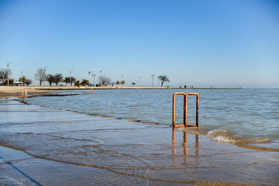 Scenic view of beach against clear blue sky