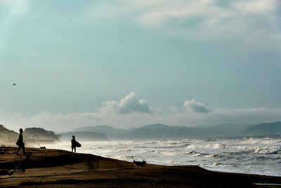 People on beach against sky