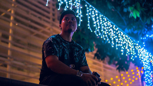 Low angle view of man looking away at night