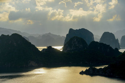 Scenic view of river by mountains against sky