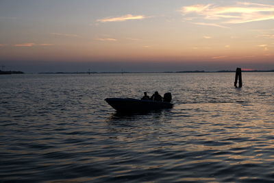 Silhouette boat in sea against sky during sunset