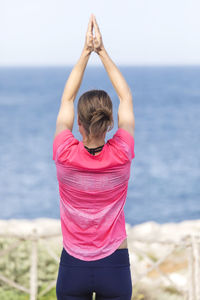 Rear view of woman standing at beach