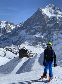 Man standing on snowcapped mountain against sky