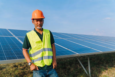 Portrait of engineer standing by solar panel