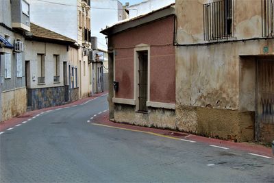 Empty alley amidst buildings in city