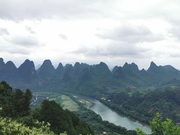 Scenic view of river and mountains against sky