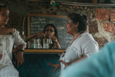 Rear view of a woman drinking glass with text