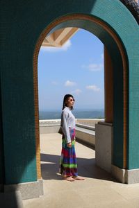 Side view of woman standing against sky